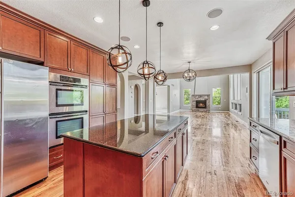 a kitchen with stainless steel appliances granite countertop a sink a oven and a refrigerator