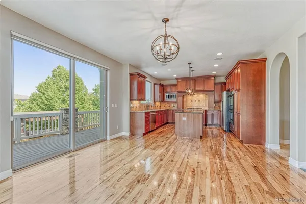 a open kitchen with a large window appliances and wooden floor