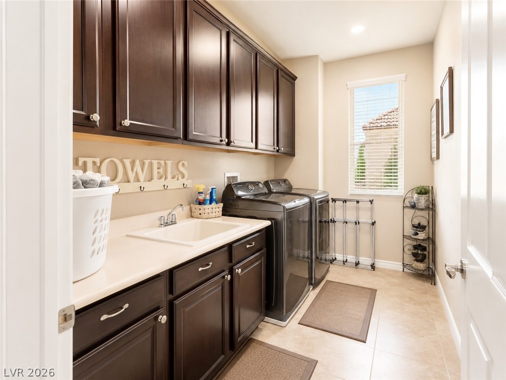 9724 University Ridge Avenue Las Vegas, NV 89149 - Photo 43 of 61 Ample cabinetry and a utility sink provide efficient organization for laundry tasks.