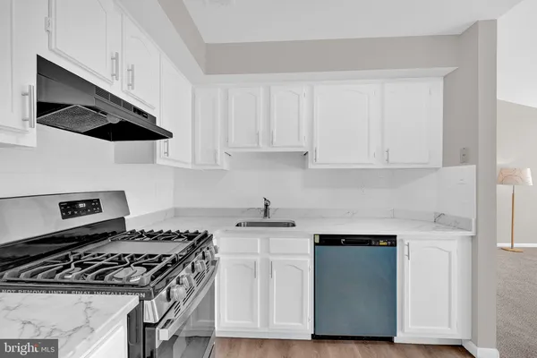a kitchen with granite countertop white cabinets and white appliances