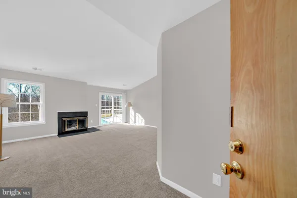 an empty room with a fireplace and windows