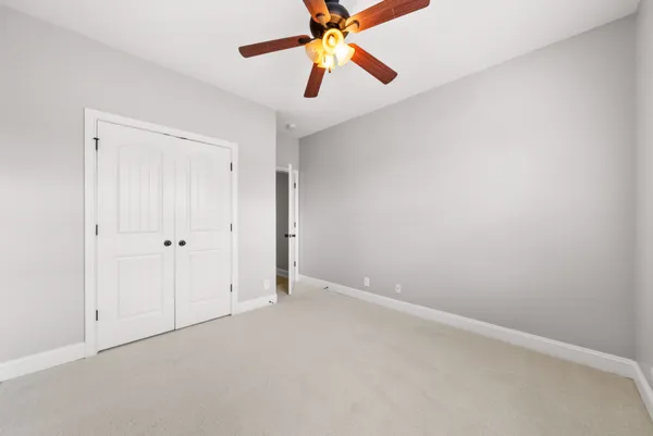 an empty room with a ceiling fan and a window