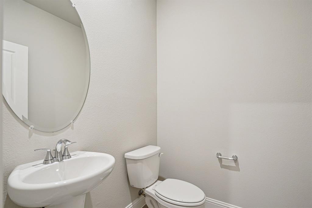 2621 Grand Cyn Street Anna, TX 75409 - Photo 16 of 37 a bathroom with a sink a toilet and mirror