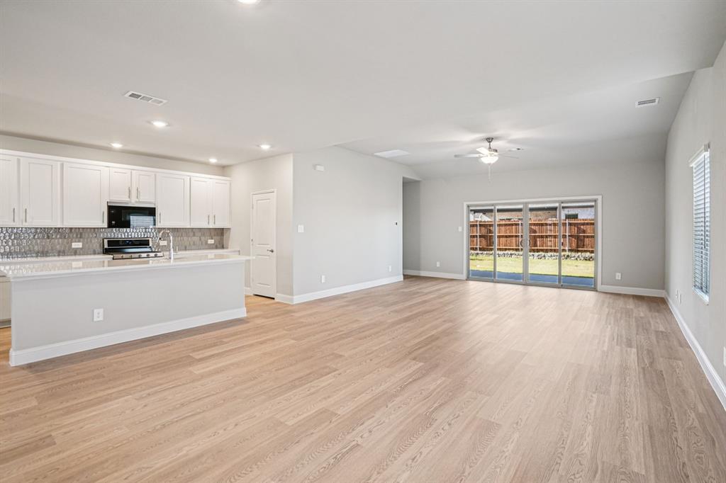 2621 Grand Cyn Street Anna, TX 75409 - Photo 3 of 37 a view of an empty room with wooden floor and a window