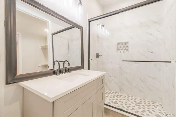 a bathroom with a sink a mirror and a shower