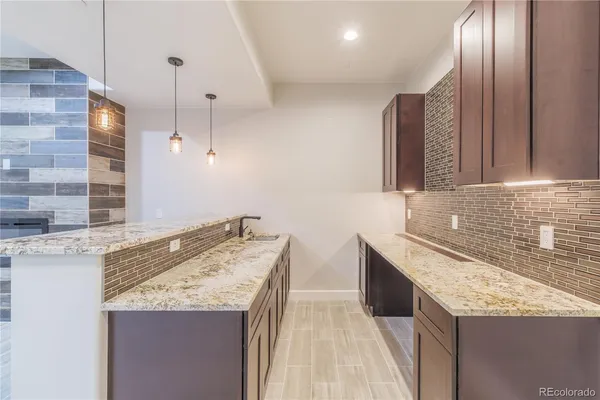 a kitchen with granite countertop kitchen island a sink stainless steel appliances and white cabinets