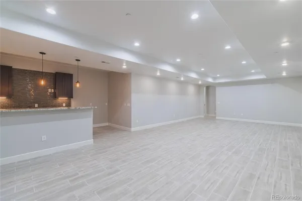a view of an empty room and kitchen appliances
