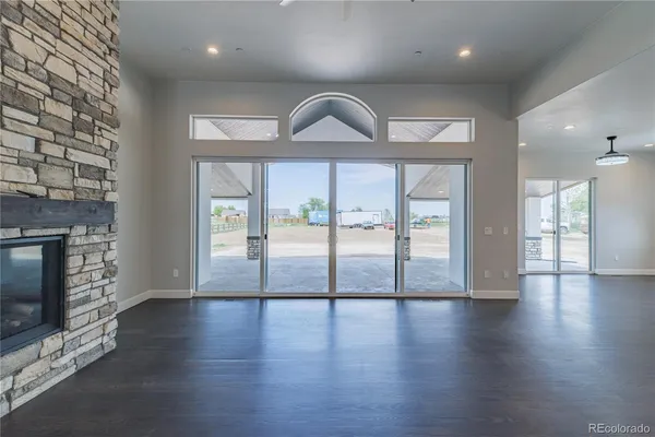 a view of an empty room with wooden floor and a fireplace