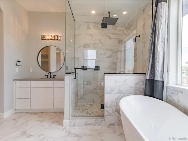 a bathroom with a tub a sink and a mirror