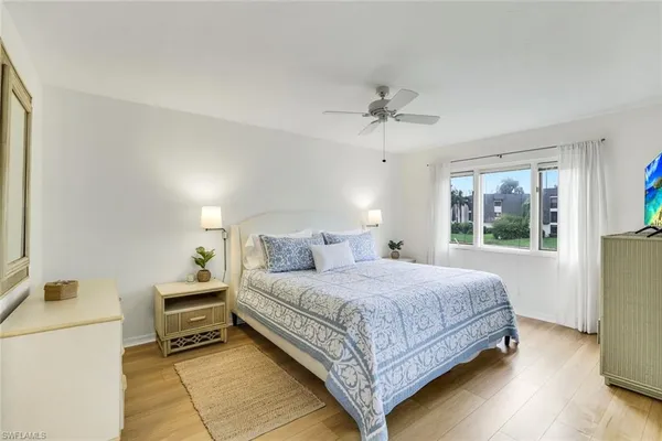 a bedroom with a balcony a bed and wooden floor
