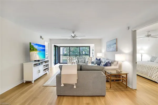 a living room with furniture a large window and a flat screen tv