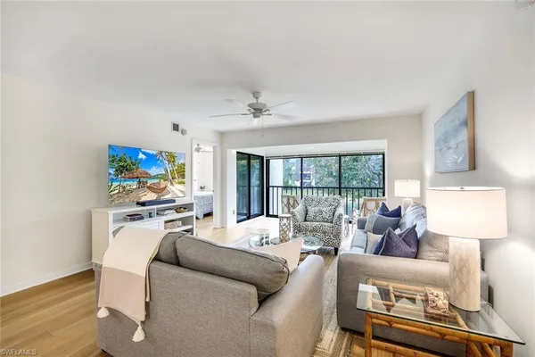 a living room with furniture a flat screen tv and a rug