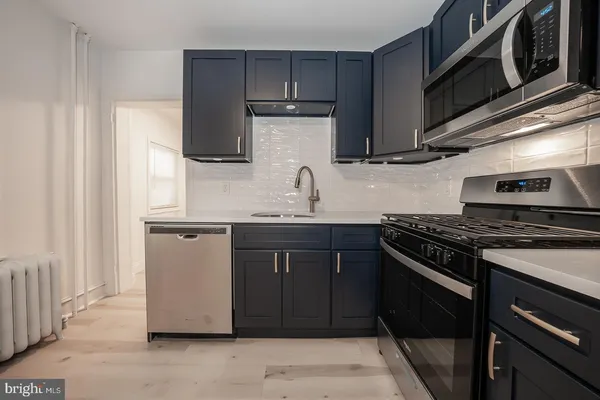 a kitchen with stainless steel appliances granite countertop a stove and a microwave