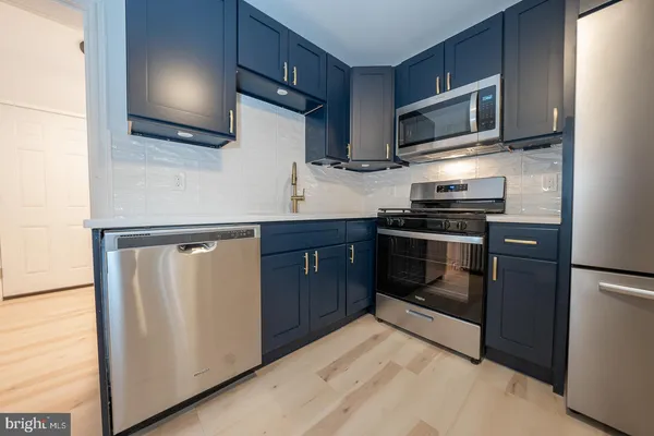 a kitchen with stainless steel appliances a stove sink and microwave