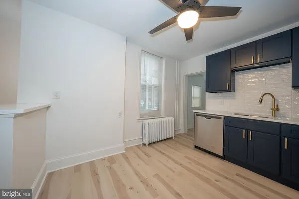 a kitchen with a sink cabinets and wooden floor