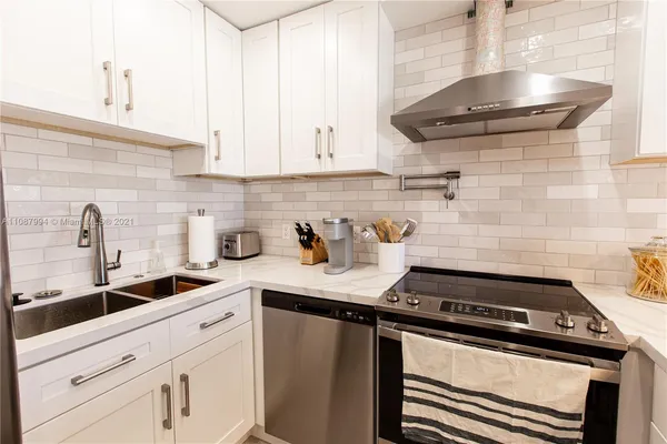 a kitchen with a stove and a white cabinets