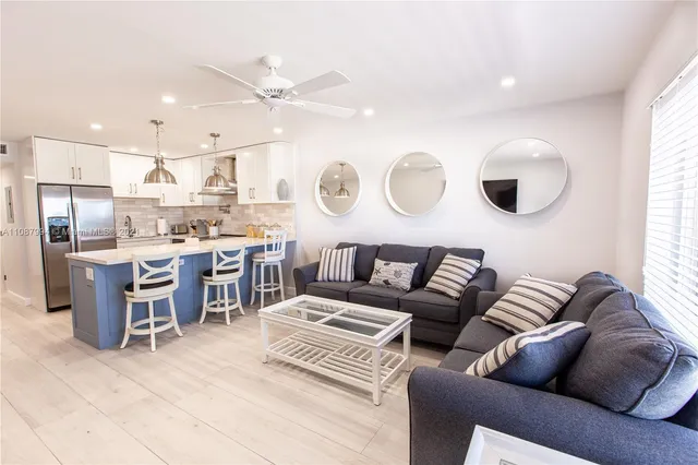 a view of a palm trees front of house with potted plants