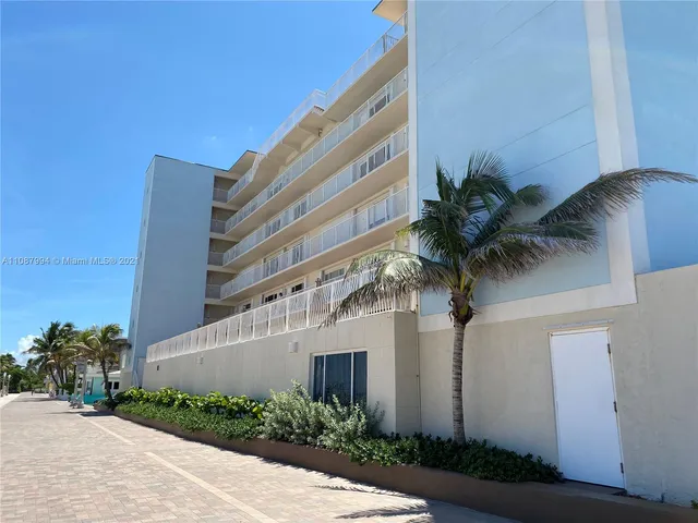 a front view of multi story residential apartment building with yard