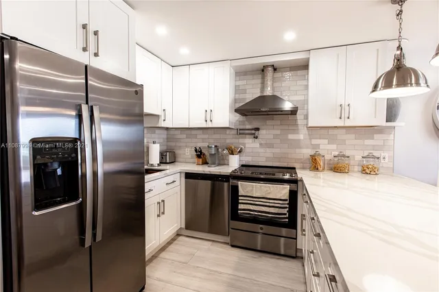 a kitchen with stainless steel appliances granite countertop a refrigerator and a stove
