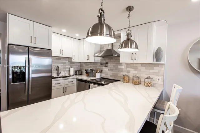 a kitchen with stainless steel appliances a stove a sink refrigerator and cabinets