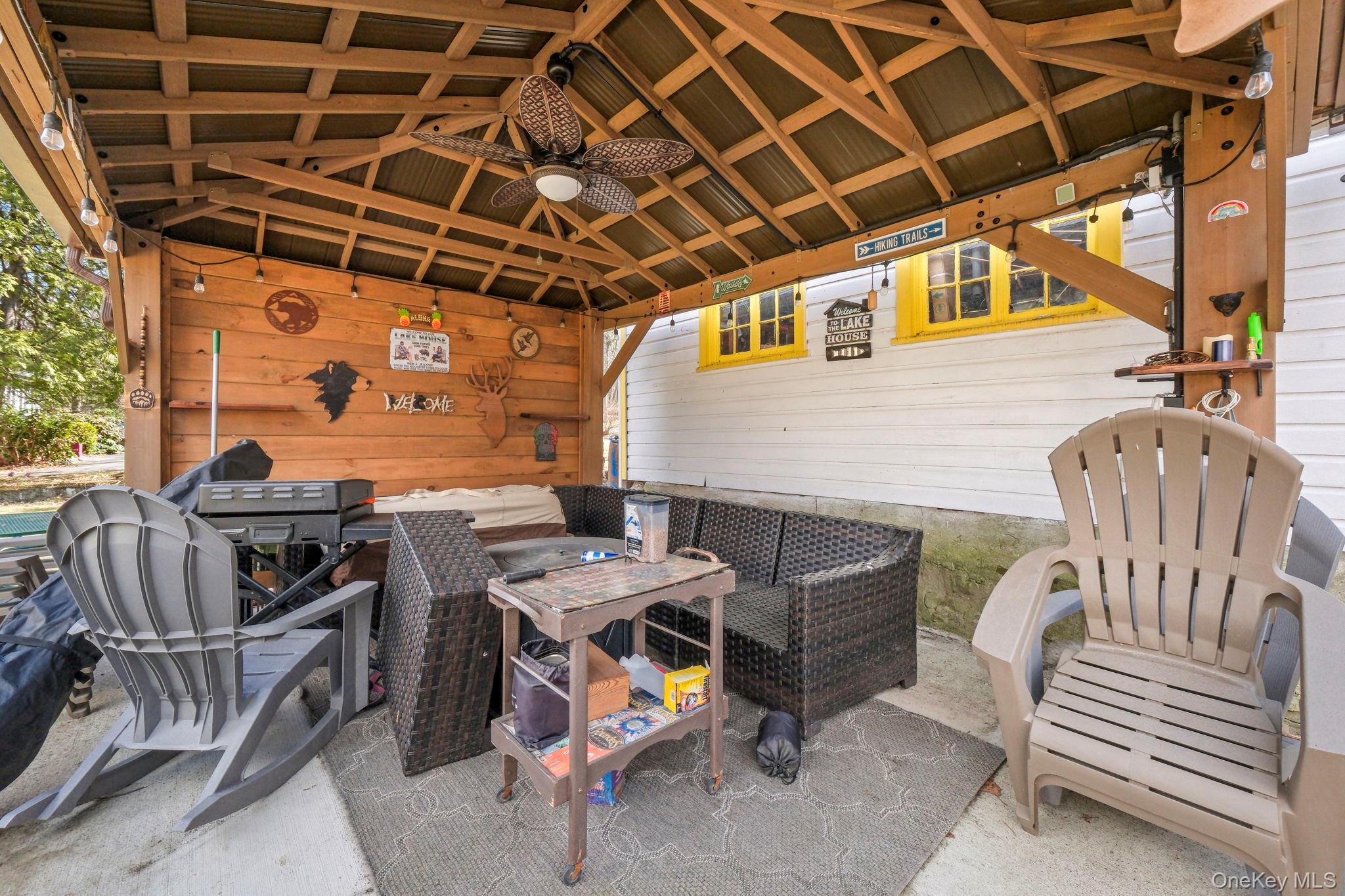 184 Yankee Lake Road Wurtsboro, NY 12790 - Photo 20 of 27 a view of a patio with a table and chairs with wooden floor