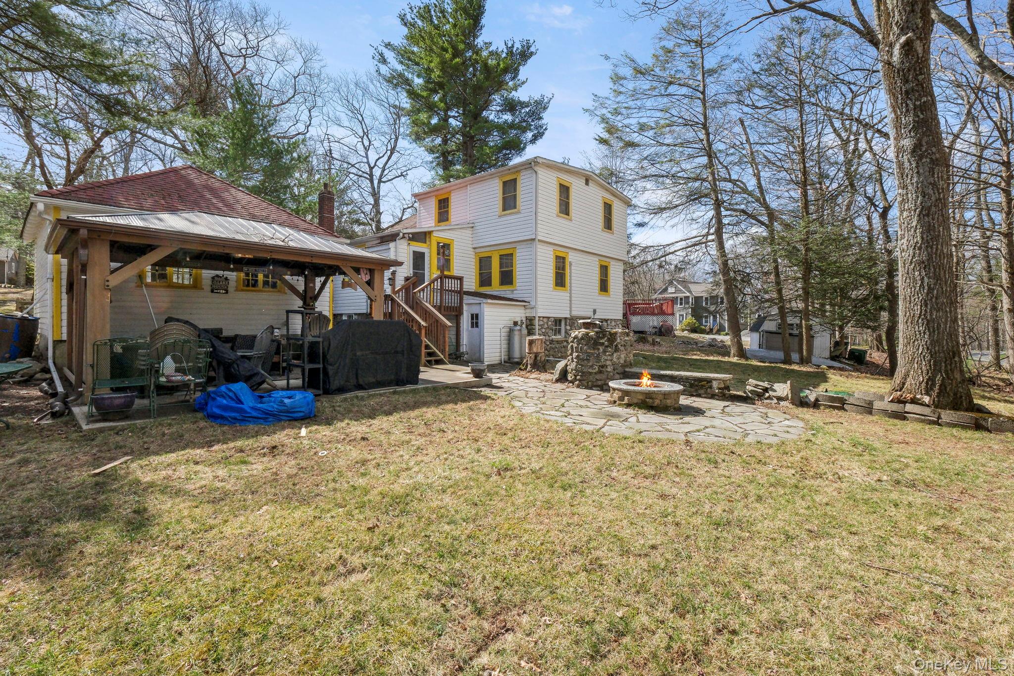 184 Yankee Lake Road Wurtsboro, NY 12790 - Photo 23 of 27 Back of property with a patio, a gazebo, an outdoor fire pit, a yard, and a storage unit
