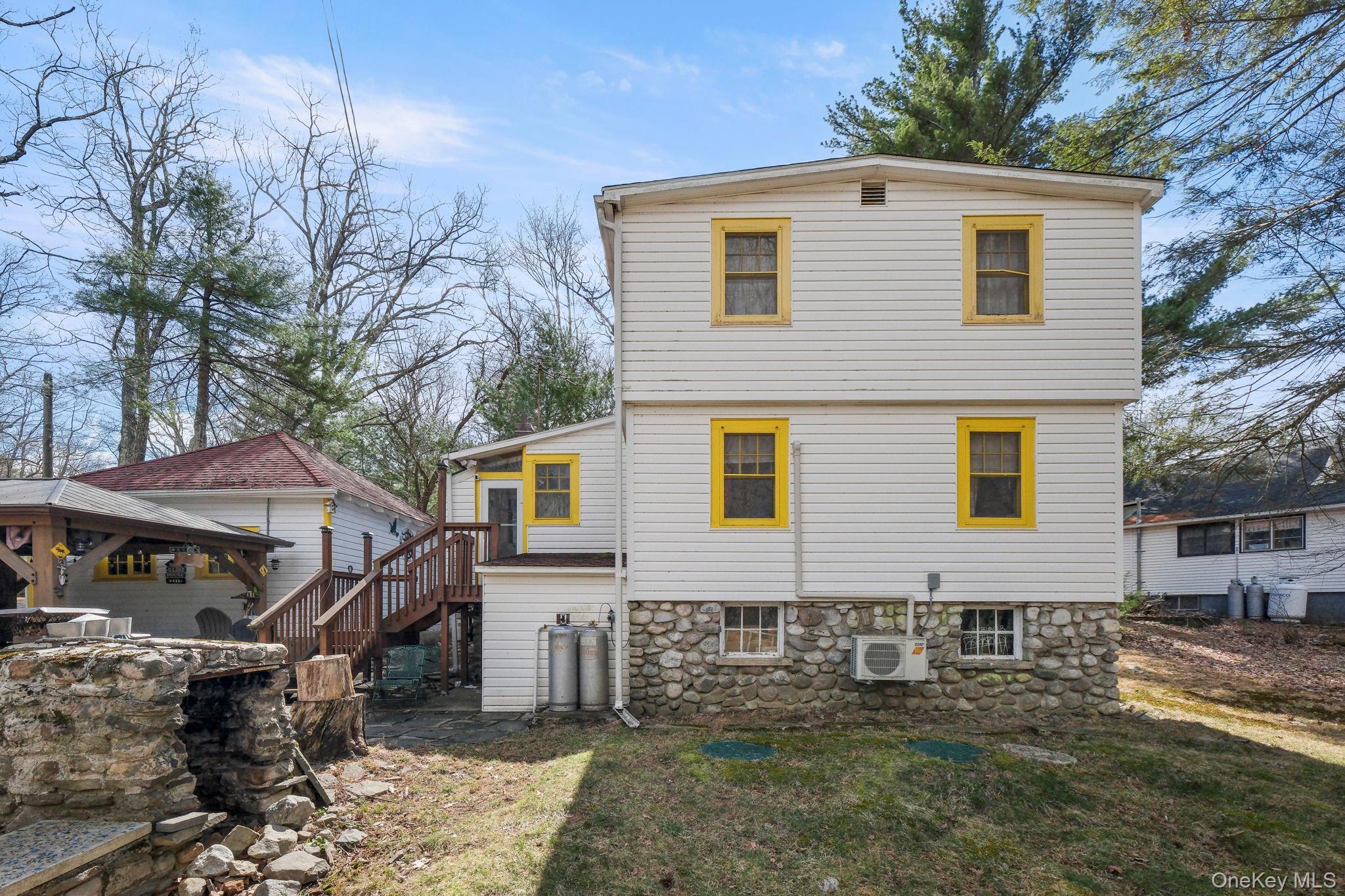 184 Yankee Lake Road Wurtsboro, NY 12790 - Photo 24 of 27 Rear view of property featuring a patio, a yard, a wooden deck, and stone siding