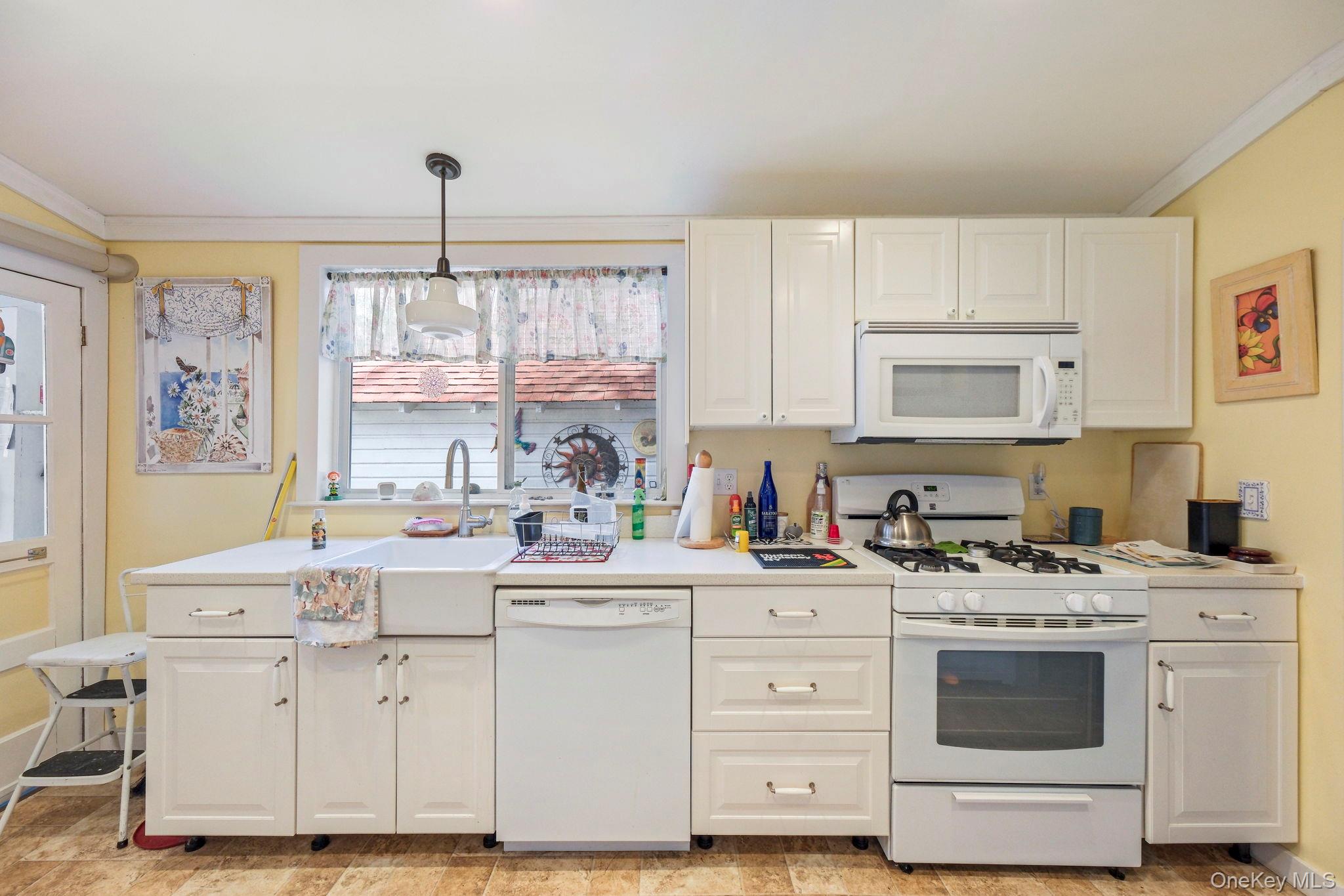 184 Yankee Lake Road Wurtsboro, NY 12790 - Photo 5 of 27 Kitchen with ornamental molding, white appliances, light countertops, decorative light fixtures, and white cabinets