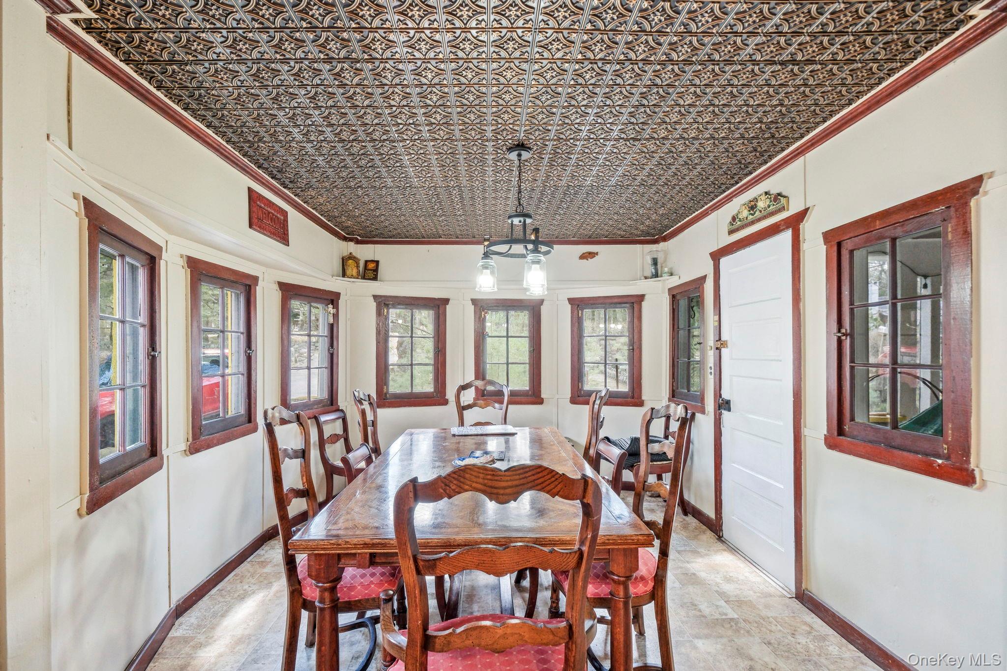 184 Yankee Lake Road Wurtsboro, NY 12790 - Photo 7 of 27 Dining area with crown molding, an ornate ceiling, unique rounded walls, and stone finish floors