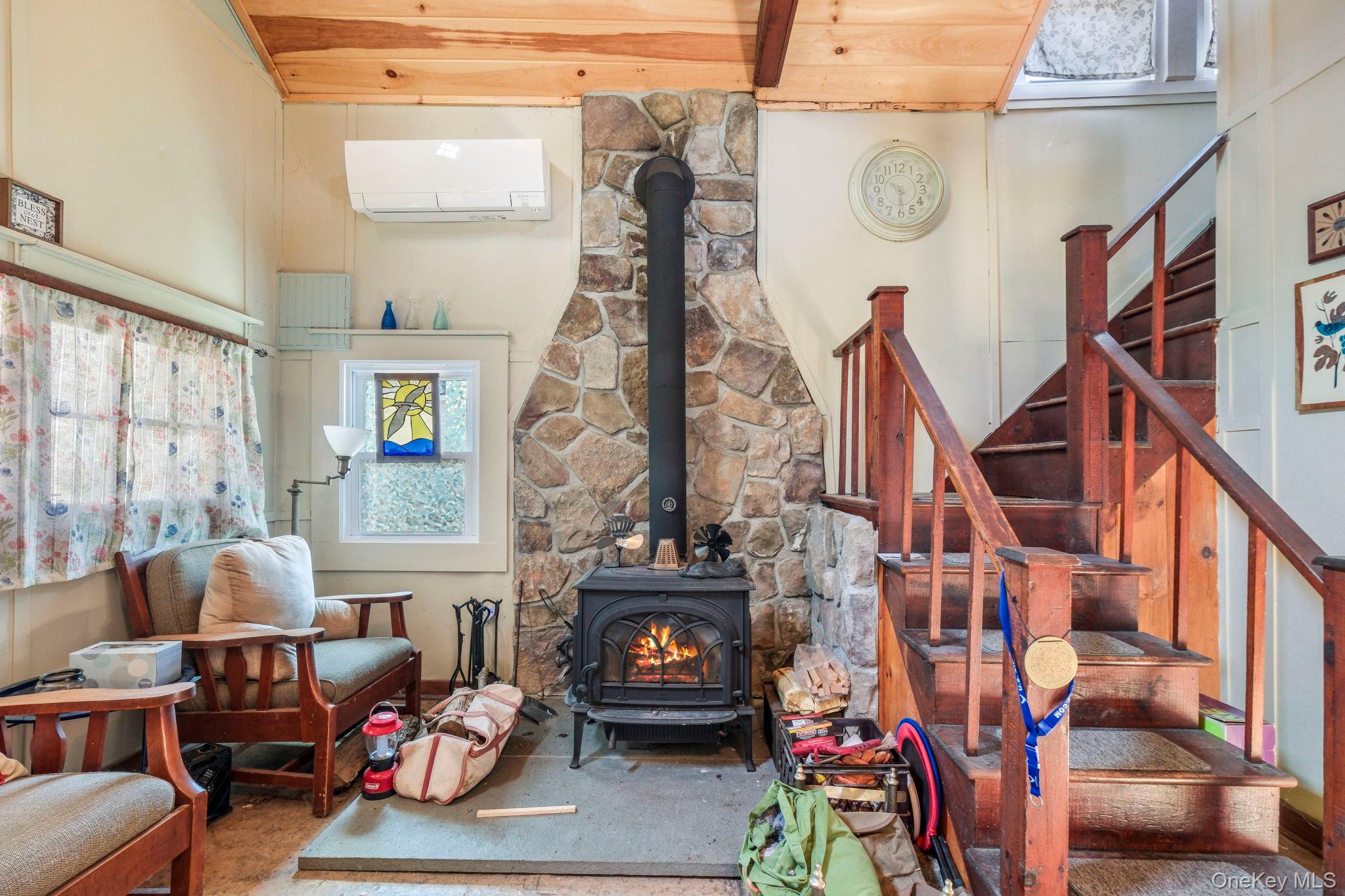 184 Yankee Lake Road Wurtsboro, NY 12790 - Photo 8 of 27 Living room featuring a wood stove, wood finished floors, healthy amount of natural light, ceiling fan, and a high wooden beamed ceiling