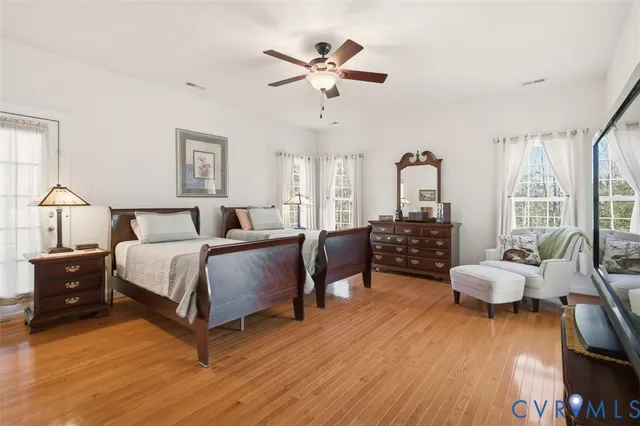 a spacious bedroom with a bed and chair