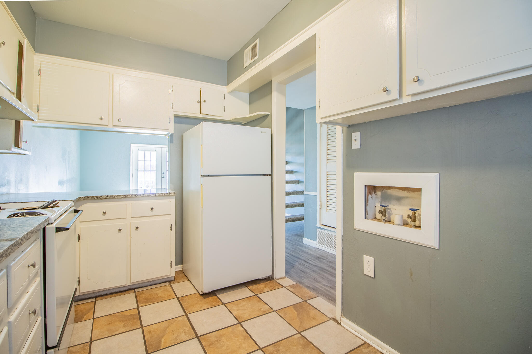 2105 49th Street Lubbock, TX 79412 - Photo 24 of 31 a kitchen with cabinets and a refrigerator