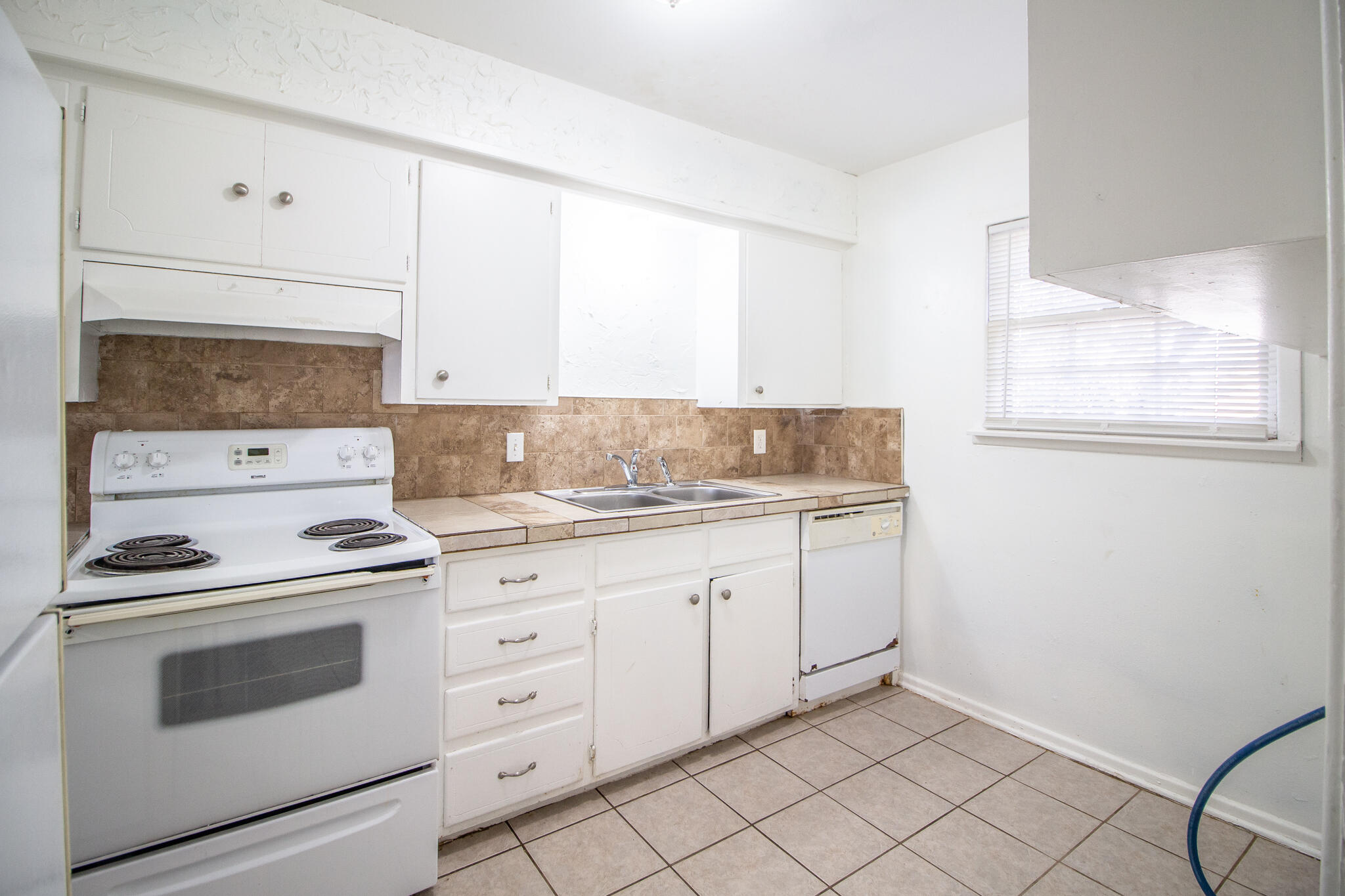 2105 49th Street Lubbock, TX 79412 - Photo 8 of 31 a kitchen with granite countertop white cabinets and white appliances