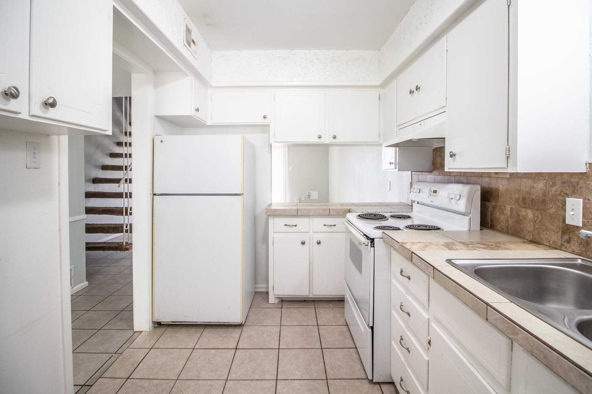 2105 49th Street Lubbock, TX 79412 - Photo 9 of 31 a kitchen with a stove a refrigerator and a sink