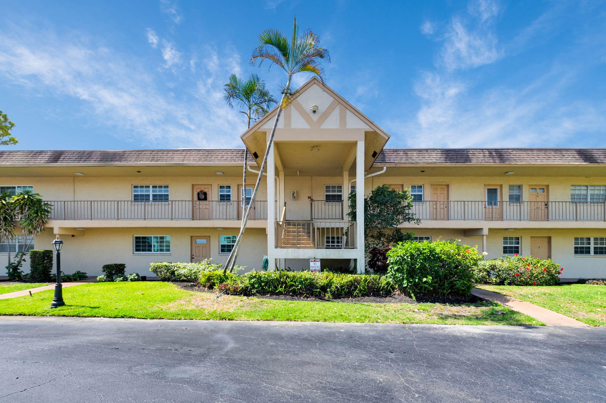 1700 Dover Road, Unit 204A Delray Beach, FL 33445 - Photo 28 of 33 a front view of a house with a yard and potted plants