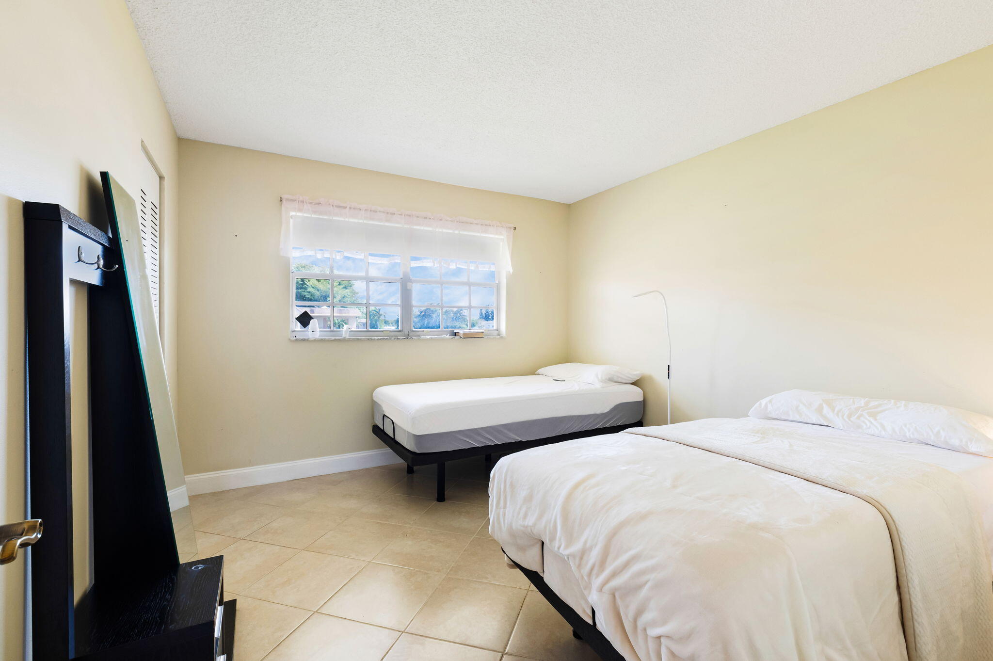 1700 Dover Road, Unit 204A Delray Beach, FL 33445 - Photo 8 of 33 a bedroom with a bed and a flat tv screen next to a window