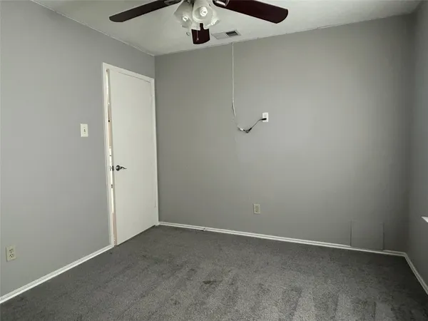 an empty room with a chandelier fan