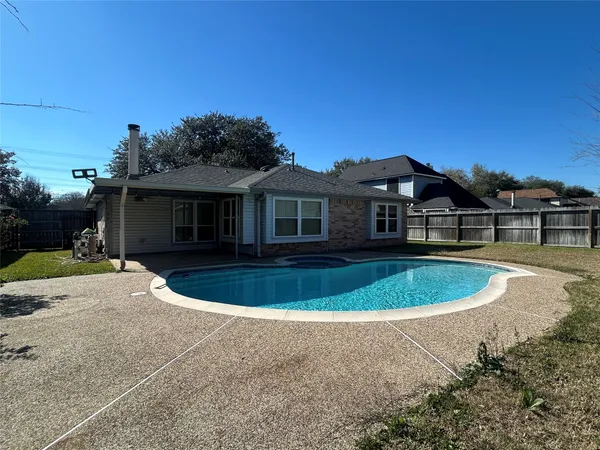 a view of a white house with a swimming pool and a yard