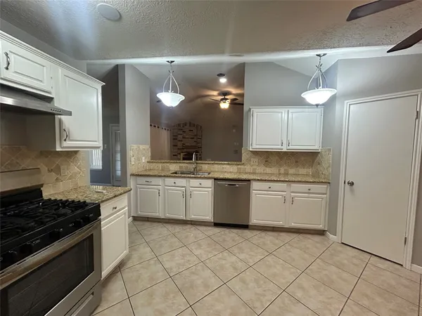 a kitchen with a sink stove and cabinets