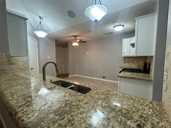 a kitchen with stainless steel appliances granite countertop a stove a sink and a refrigerator