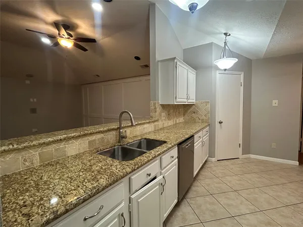 a kitchen with granite countertop a sink and cabinets