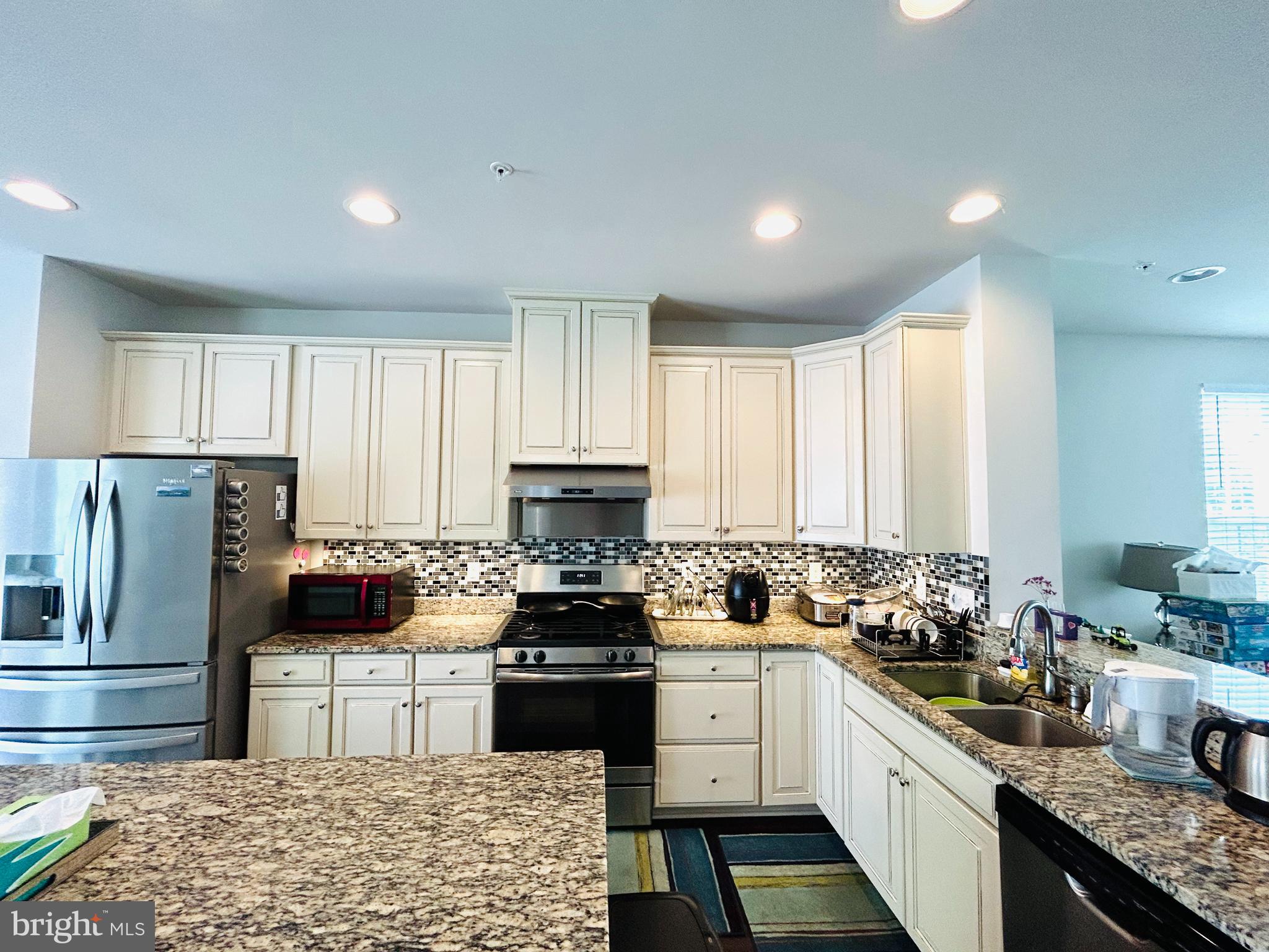 113 Patriots Path Malvern, PA 19355 - Photo 11 of 24 a kitchen with refrigerator a stove a sink dishwasher and white cabinets with wooden floor