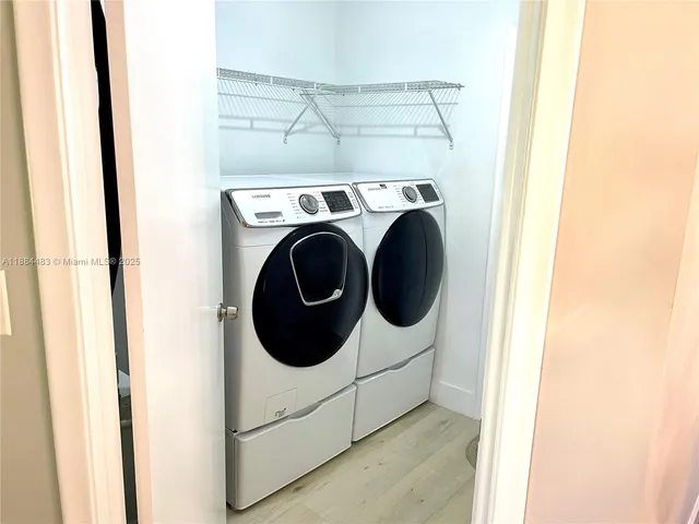 a view of a patio with table and chairs under an umbrella with large trees
