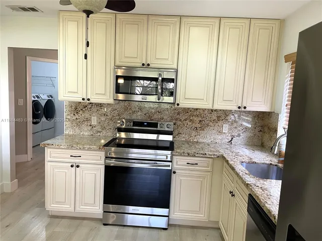 a kitchen with a stove a sink and a microwave