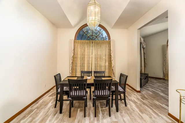 a dining room with furniture a chandelier and wooden floor