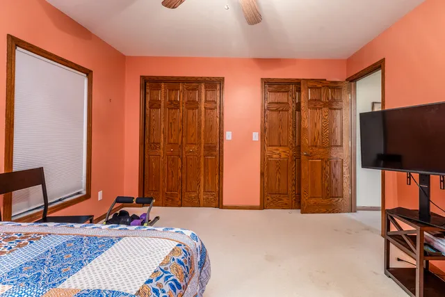 a bedroom with bed a desk and chair