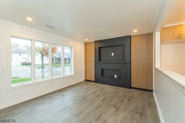 a view of an empty room with a window and closet area