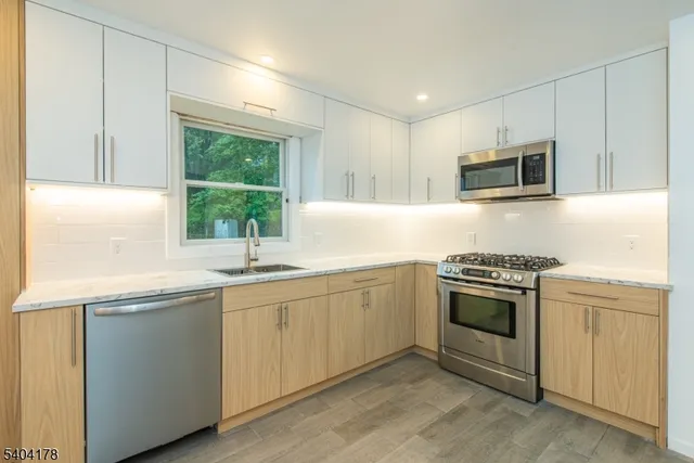 a kitchen with granite countertop a sink and stainless steel appliances