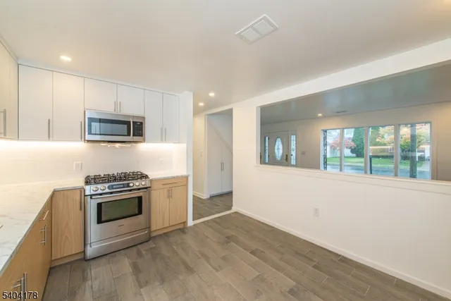 a kitchen with granite countertop a stove and a refrigerator