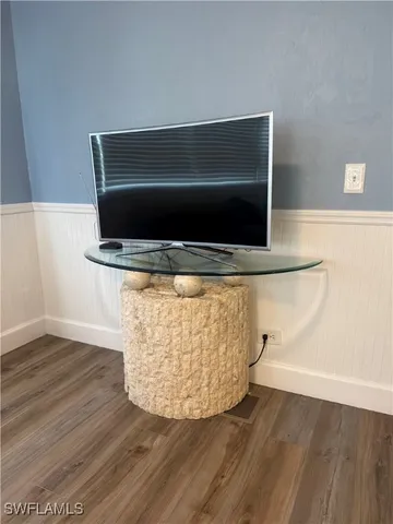 a room with wooden floor and mirror